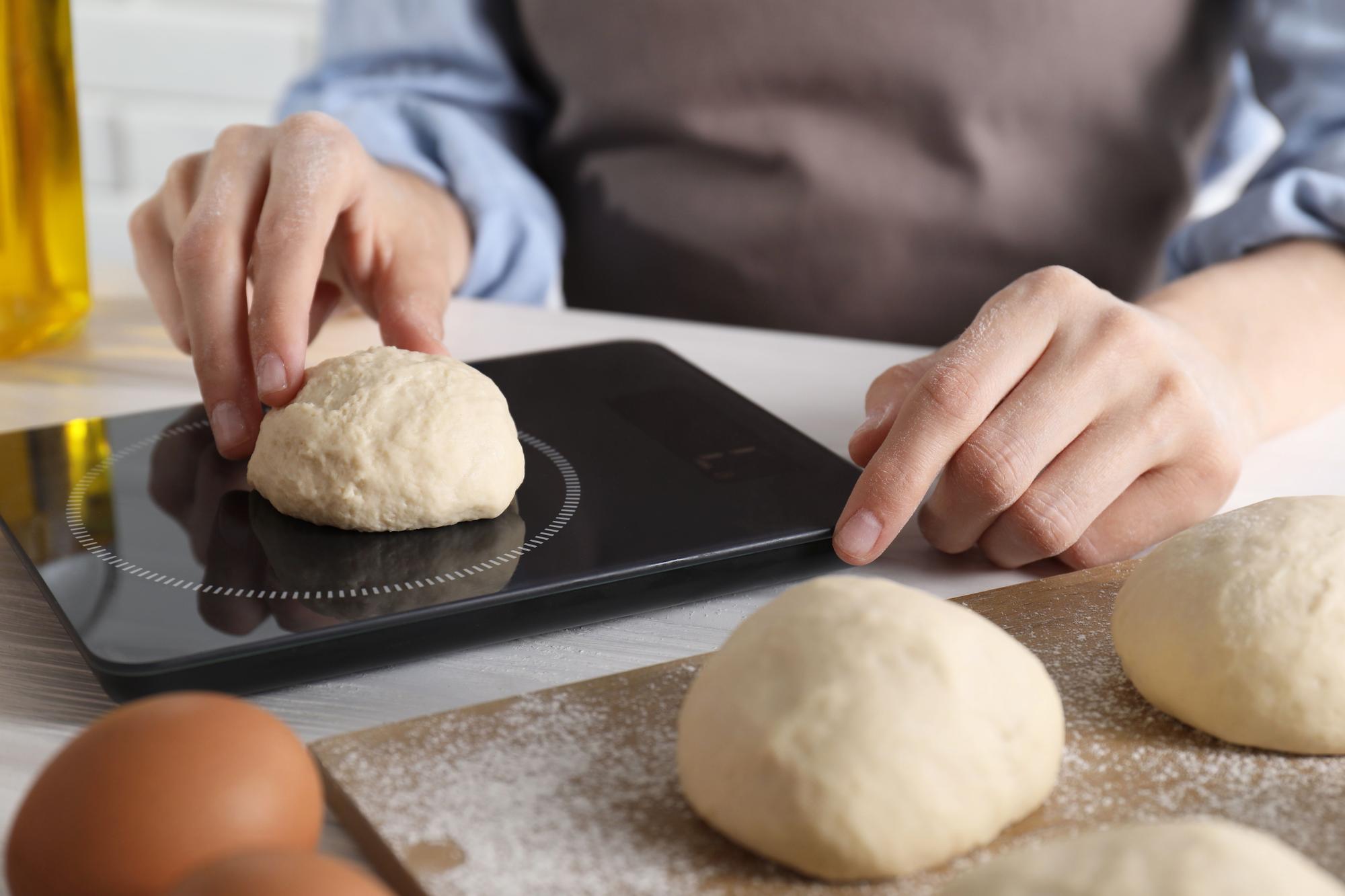 Close up of hands kneading dough with sensor